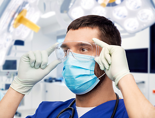 Image showing male doctor in goggles, mask and gloves