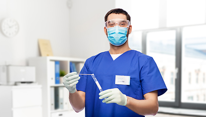 Image showing male doctor in mask with cotton swab and test tube