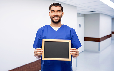 Image showing happy smiling male doctor or nurse with chalkboard