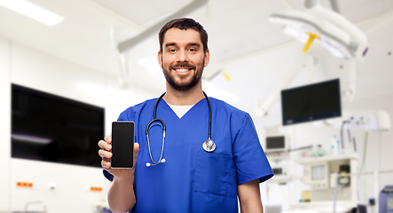 Image showing smiling doctor or male nurse with smartphone