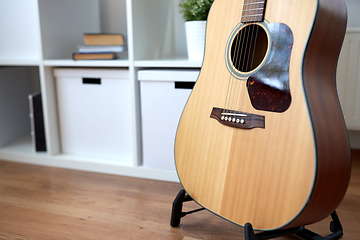 Image showing close up of acoustic guitar on stand at home