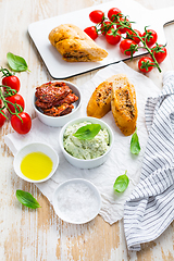 Image showing Avocado spread and sun dried tomatoes with olive oil as antipasto and baguette