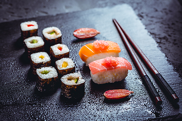 Image showing Assortment of vegan sushi with vegetables, seitan, Konjac plant, tofu as fish substitutes, with finger lime as caviar on black