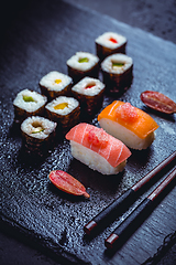 Image showing Assortment of vegan sushi with vegetables, seitan, Konjac plant, tofu as fish substitutes, with finger lime as caviar on black