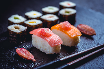 Image showing Assortment of vegan sushi with vegetables, seitan, Konjac plant, tofu as fish substitutes, with finger lime as caviar on black