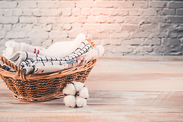 Image showing A stack of organic kitchen towels in a basket with cotton flower. Concept of sustainability