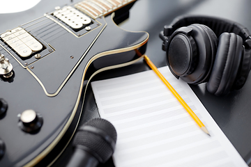 Image showing close up of guitar, music book and headphones