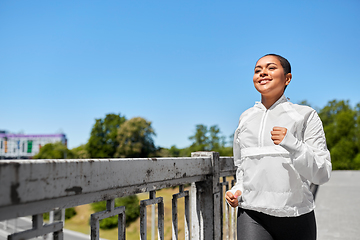 Image showing african american woman running along bridge