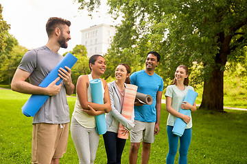 Image showing group of happy people with yoga mats at park