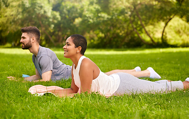 Image showing happy people doing yoga at summer park