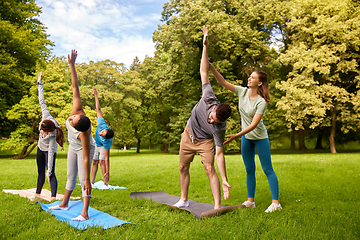 Image showing group of people doing yoga with instructor at park