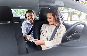 Image showing female car driver taking money from passenger