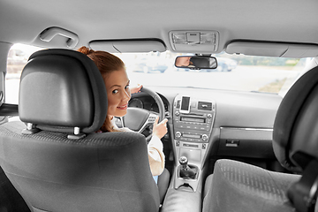 Image showing smiling woman or female driver driving car in city