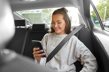 Image showing happy smiling woman in car using smartphone