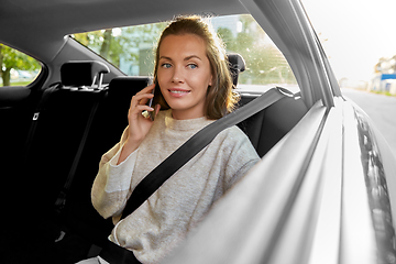 Image showing happy smiling woman in car calling on smartphone