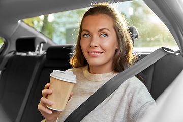 Image showing smiling woman or passenger drinking coffee in car