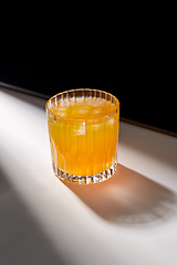 Image showing glass of orange juice with ice on table