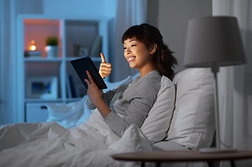 Image showing woman with tablet pc in bed has video call at night