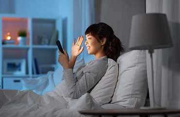 Image showing woman with phone having video call in bed at night