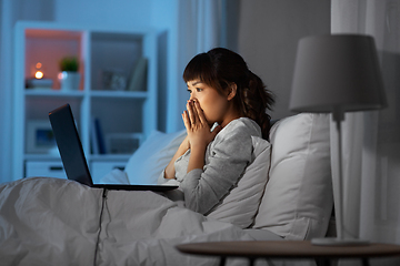 Image showing stressed woman with laptop working in bed at night