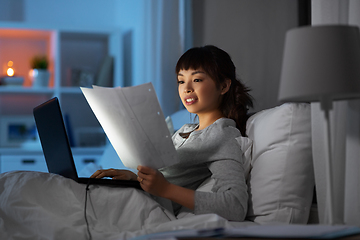 Image showing woman with laptop working in bed at night