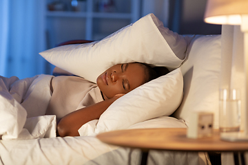 Image showing angry african woman lying in bed and closing ears