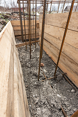 Image showing Reinforcement of the strip foundation, the trench is partially covered with earth