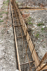 Image showing Fragment of reinforcement of the strip foundation, the trench is partially covered with earth