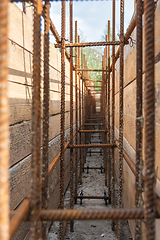 Image showing Close-up of tied reinforcement and mounted strip foundation formwork, view inside the trench