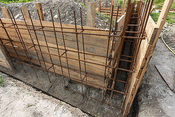 Image showing Tied rebar and mounted formwork close-up before pouring the strip foundation when building a house