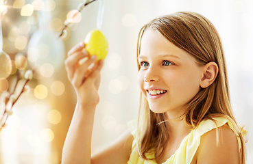 Image showing girl decorating willow by easter eggs at home