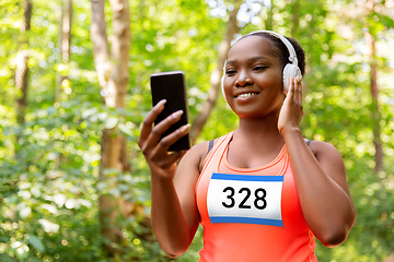 Image showing female marathon runner with headphones and phone