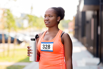 Image showing female marathon runner drinking water from bottle