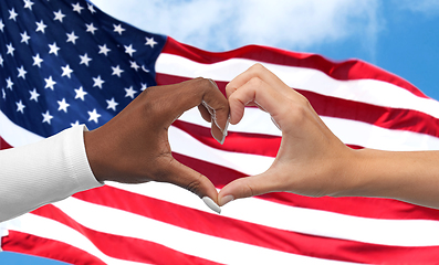 Image showing black and white hands making heart gesture