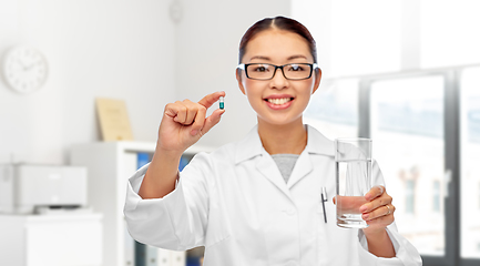 Image showing asian doctor with medicine and glass of water