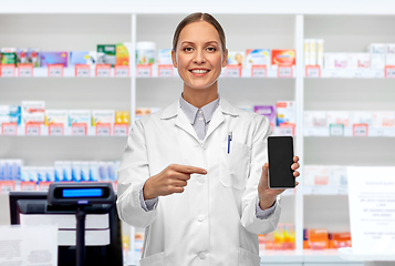 Image showing happy female doctor with smartphone at pharmacy