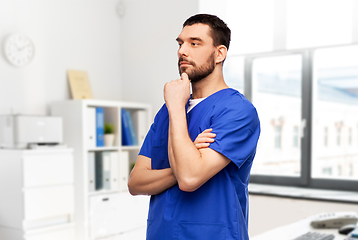 Image showing thinking doctor or male nurse in blue uniform