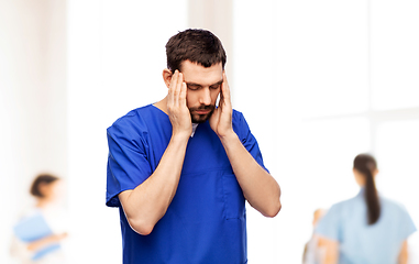 Image showing stressed doctor or male nurse in blue uniform