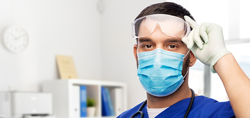 Image showing male doctor in goggles, mask and gloves