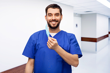 Image showing smiling male doctor in blue uniform with mask