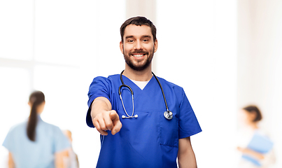 Image showing smiling doctor or male nurse pointing to camera