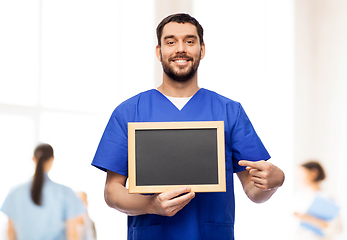 Image showing happy smiling male doctor or nurse with chalkboard