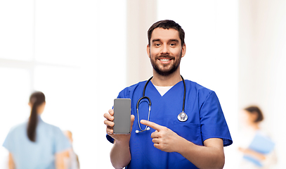 Image showing smiling doctor or male nurse with smartphone