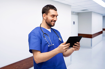 Image showing smiling doctor or male nurse using tablet computer