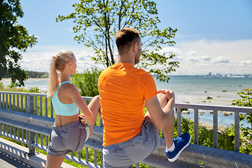 Image showing young sporty couple stretching legs