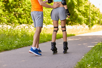 Image showing happy couple with roller skates riding outdoors