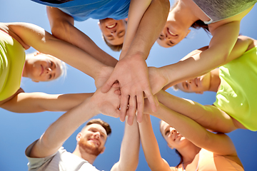 Image showing group of happy sporty friends stacking hands