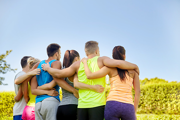 Image showing group of happy sporty friends hugging outdoors