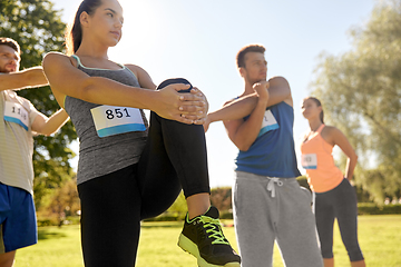 Image showing happy people exercising with trainer at park