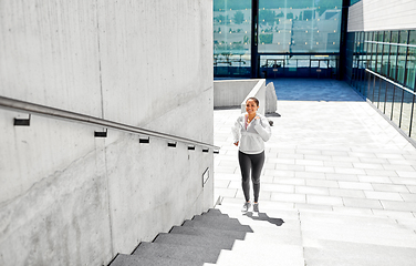 Image showing african american woman running upstairs outdoors